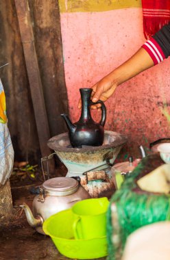 Geleneksel Etiyopya kahvesini hazırlayan Buna, Amhara Bölgesi 'nde küçük metal bir sobada, siyah Jebena' yı tutan bir elle. Etiyopya