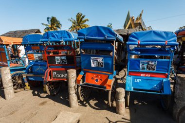 Toamasina, Madagaskar - 17 Ekim 2016: Geleneksel insan gücüyle çalışan rickshaws, pousse-pousse olarak bilinir, Madagaskar 'ın ana liman kentinde işlek bir pazar alanı yakınlarında yolcuları bekliyor.