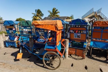 Toamasina, Madagaskar - 17 Ekim 2016: Geleneksel insan gücüyle çalışan rickshaws, pousse-pousse olarak bilinir, Madagaskar 'ın ana liman kentinde işlek bir pazar alanı yakınlarında yolcuları bekliyor.
