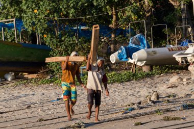 Men transports cargo from ship to shipyard