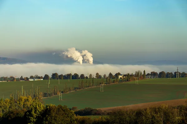 Smoking chimneys in from factory hidden in mist — Stock Photo, Image