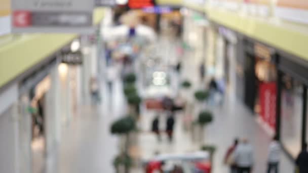 Blurred people in motion, people walking in shopping center, out of focus movie shot — Stock Video