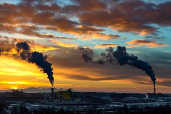 Sunrise silhouette of smoking factory — Stock Photo, Image