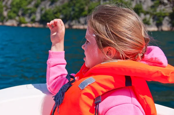 El retrato de una chica en el chaleco salvavidas sentada en un barco — Foto de Stock