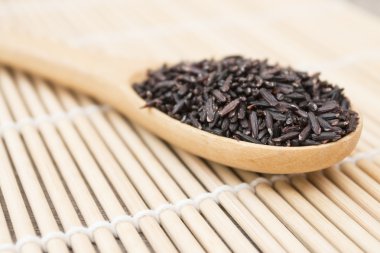 Siyah pirinç organik tahta kaşık koymak