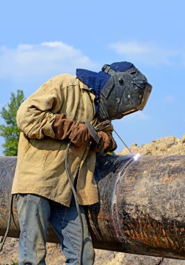 Welder on the pipeline repairs clipart