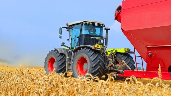 Trekker met een tank voor het transport van graan op het veld. — Stockfoto