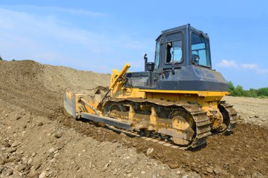 endüstriyel bir manzara içinde bir bina sitesindeki buldozer.