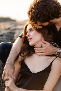 Sevgi dolu çift kayalık arazide birlikte dinleniyor.