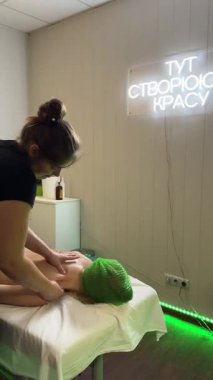 Kadın masaj terapisti profesyonel spa ortamında müşterinin kollarına ve omuzlarına masaj yapıyor.