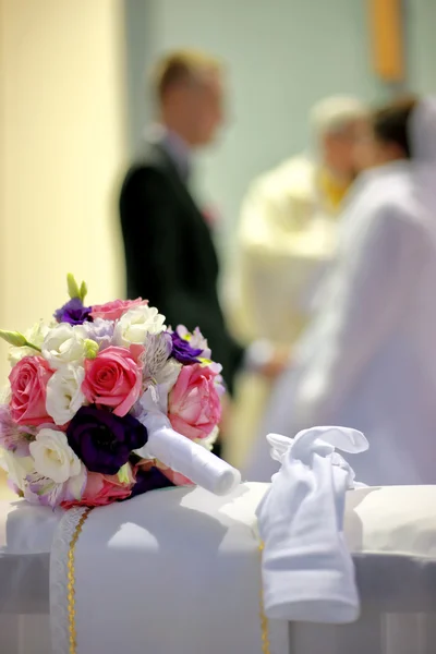 Le bouquet des mariées à l'église sur le genou — Photo