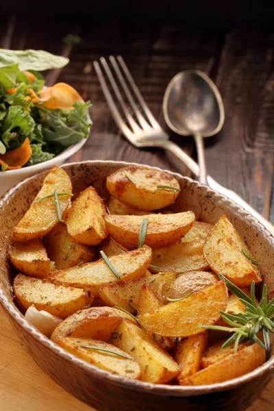 Roasted potato in brown bowl with fresh salad on wooden table — Stock Photo, Image