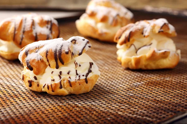 Cream puff cake with filling and chocolate icing — Stock Photo, Image