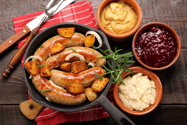 White sausages with potatoes baked in a frying pan — Stock Photo, Image