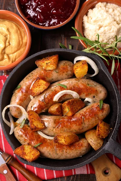 Embutidos blancos con patatas cocidas en una sartén —  Fotos de Stock