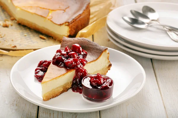 Fatia de bolo de queijo com geléia de cereja — Fotografia de Stock