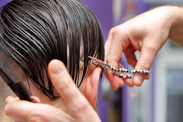 Cabeleireiro aparar o cabelo com tesoura — Fotografia de Stock