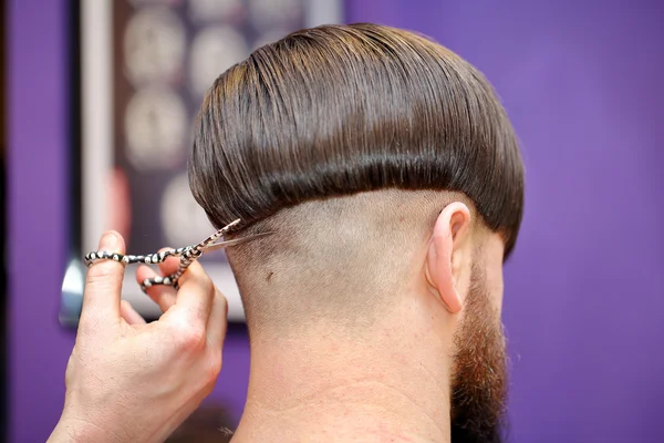 Парикмахер стрижет волосы ножницами — стоковое фото