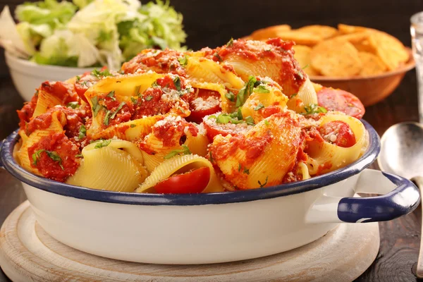 Lumaconi pasta с томатным соусом, брушеткой и салатом — стоковое фото