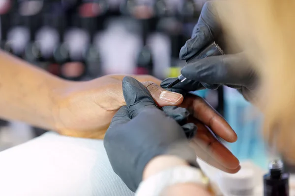 Manicura maestro hace manicura en la mano de mujer joven —  Fotos de Stock