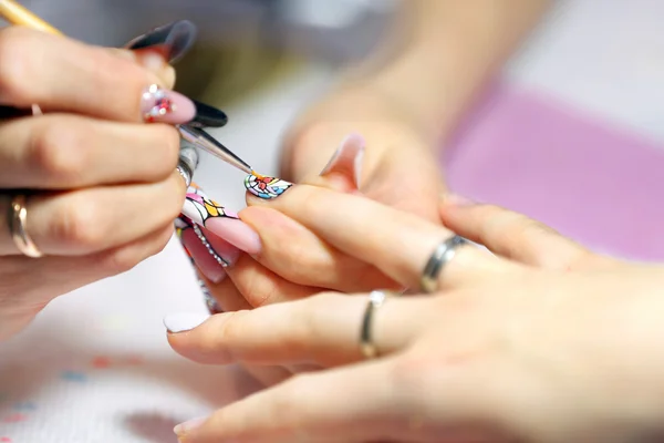 Manicura maestro hace manicura en la mano de mujer joven —  Fotos de Stock