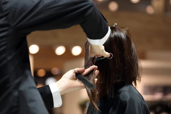 Hairdresser trimming brown hair with scissors — Stock Photo, Image