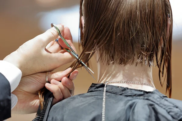 Coiffeur coupe cheveux bruns avec des ciseaux — Photo