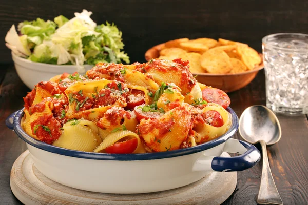 Lumaconi pasta с томатным соусом, брушеткой и салатом — стоковое фото