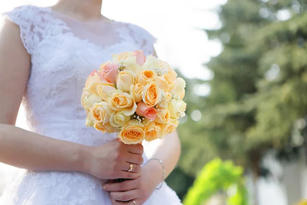 Bride with wedding rose bouquet outdoors
