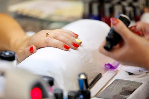 Manicurista maestro fa manicure sulla mano giovane donna — Foto Stock