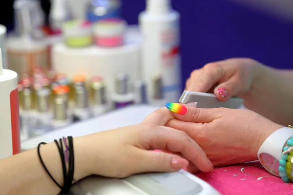 Manicura maestro hace manicura en la mano de mujer joven —  Fotos de Stock