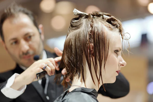 POZNAN, POLAND - MAY 07. 2016: Hairdresser trimming brown hair w — Stock Photo, Image