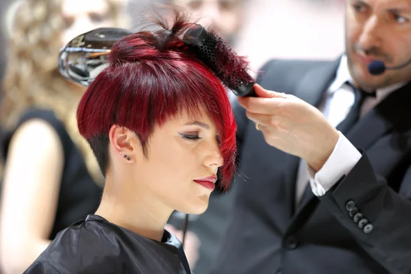 POZNAN, POLAND - MAY 07. 2016: Hairdresser arranging hairdo usin — Stock Photo, Image