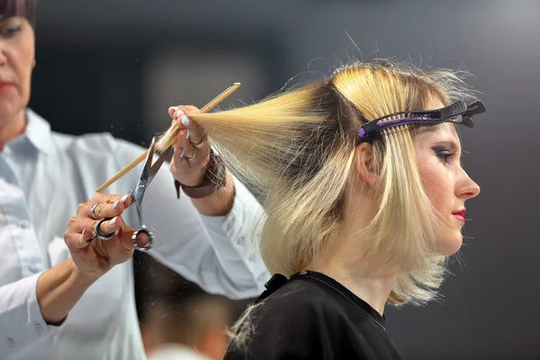 POZNAN, POLAND - MAY 07. 2016: Hairdresser trimming blond hair w — Stock Photo, Image