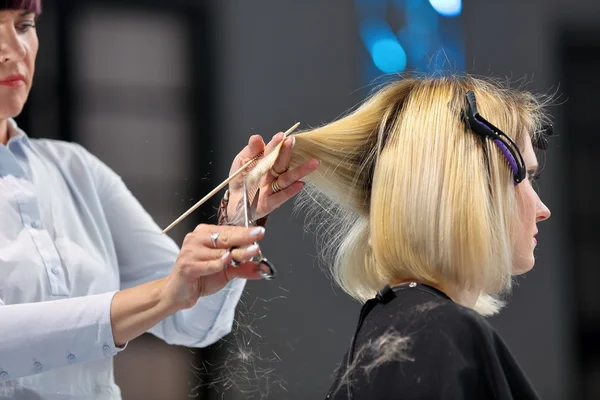 Poznań, Polska - maj 07. 2016: Fryzjer przycinanie blond włosy w — Zdjęcie stockowe