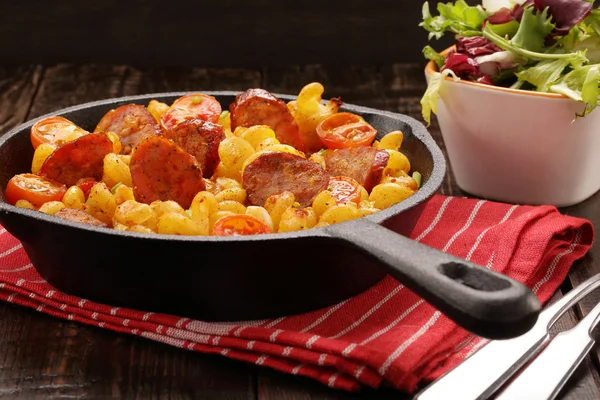 Casserole with chorizo sausage on wooden background — Stock Photo, Image