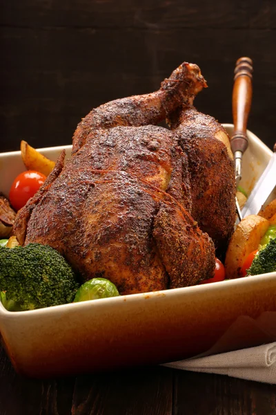 Whole roast chicken with vegetables in bowl — Stock Photo, Image