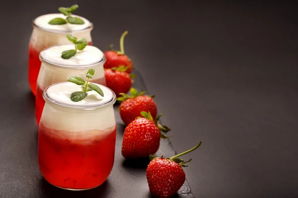 Leckeres Erdbeerdessert im Glas auf Holzgrund — Stockfoto