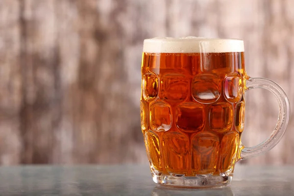 Pint of beer on wooden background with space for text