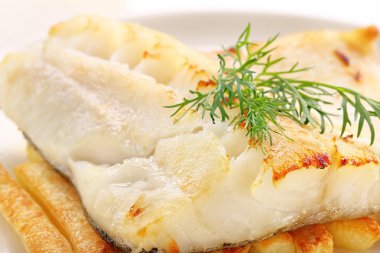 Pişmiş balık ve cips beyaz plaka üzerinde