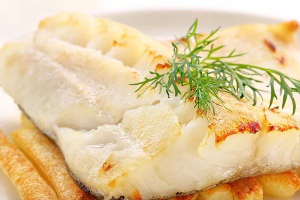 Pesce al forno e patatine su piatto bianco — Foto Stock