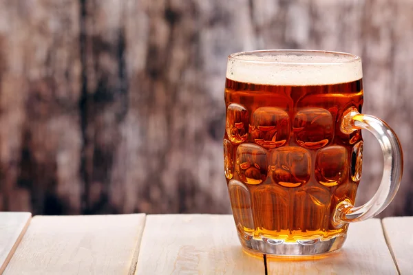 Pint of beer on wooden background with space for text