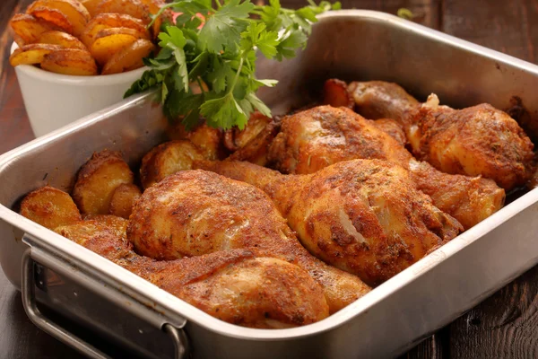 Roasted chicken legs with potato chips and vegetables — Stock Photo, Image