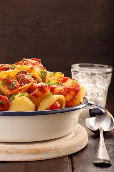 Lumaconi pasta med tomatsås på trä bakgrund — Stockfoto