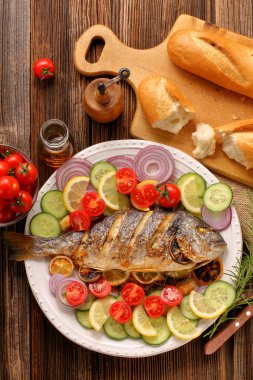 Baget ve plaka üzerinde sebze ızgara balık