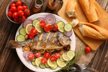 Kavrulmuş patates ve sebze plaka üzerinde ızgara balık