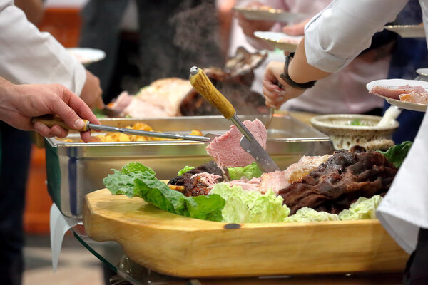 Кук нарезанный жареное мясо на вечеринке
