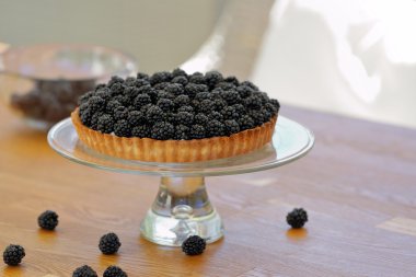 Ahşap arka plan üzerinde taze böğürtlen ile tart