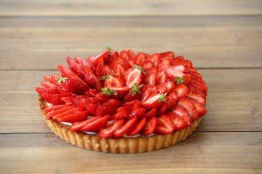 Tahta arka planda taze çilekli turta.