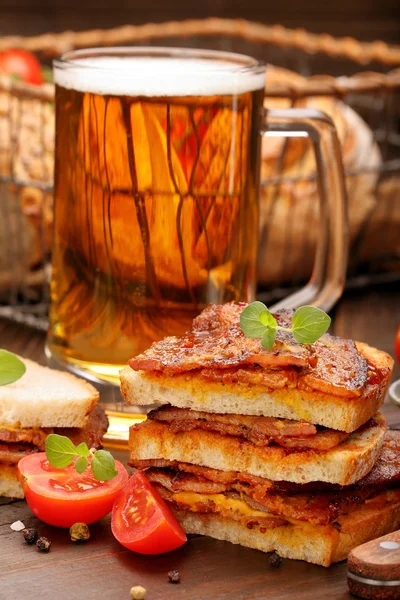 Sandwich mit gebratenem Speck und Bier auf Holzboden — Stockfoto